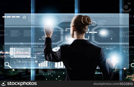 Technology innovations. Rear view of businesswoman touching icon of digital screen