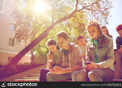 technology, internet addiction and people concept - group of teenage friends or high school students with smartphones outdoors. group of teenage friends with smartphones outdoors