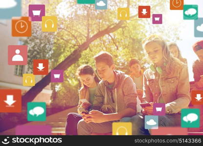 technology, internet addiction and people concept - group of teenage friends or high school students with smartphones and virtual icons outdoors. group of teenage friends with smartphones outdoors
