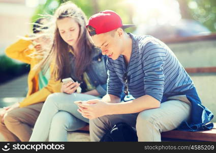 technology, internet addiction and people concept - happy teenage friends with smartphones outdoors. happy teenage friends with smartphones outdoors. happy teenage friends with smartphones outdoors