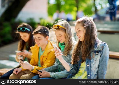 technology, internet addiction and people concept - happy teenage friends with smartphones outdoors