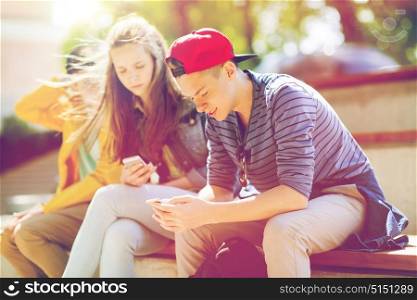 technology, internet addiction and people concept - happy teenage friends with smartphones outdoors. happy teenage friends with smartphones outdoors