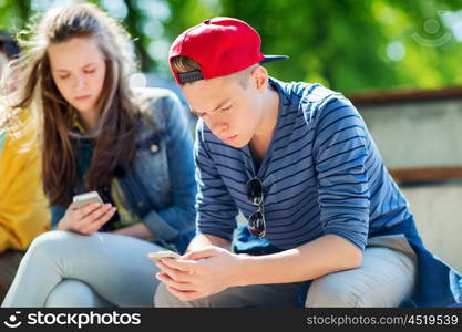 technology, internet addiction and people concept - teenage friends with smartphones outdoors