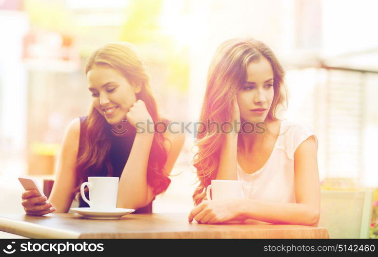 technology, internet addiction, lifestyle, friendship and people concept - young women or teenage girls with smartphones and coffee cups at cafe outdoors. women with smartphones and coffee at outdoor cafe