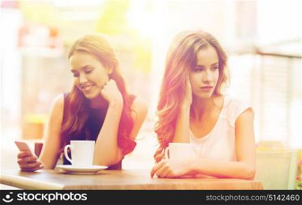 technology, internet addiction, lifestyle, friendship and people concept - young women or teenage girls with smartphones and coffee cups at cafe outdoors. women with smartphones and coffee at outdoor cafe