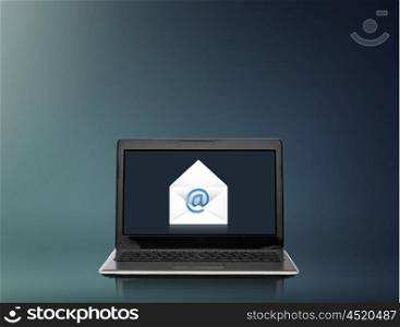 technology, internet and communication concept - laptop computer with letter and email icon on screen over gray background