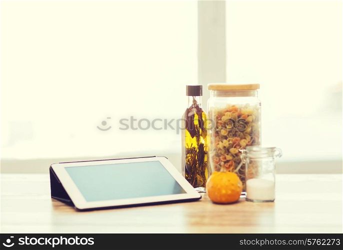 technology, internet and cooking concept - close up of tablet pc computer, olive oil, pasta, salt and pumpkin