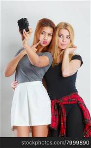 Technology internet and happiness concept. Young women blonde and mixed race taking self picture selfie with smartphone camera . Two beautiful young women making selfie