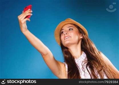 Technology internet and happy people concept - teen girl taking self picture selfie with smartphone camera, woman using cell phone on blue