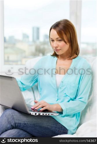 technology, internet and home concept - woman with laptop computer at home