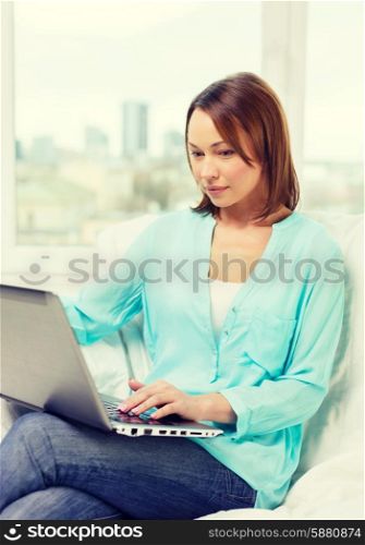 technology, internet and home concept - woman with laptop computer at home