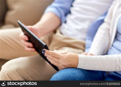 technology, internet and people concept - close up of couple with tablet pc computer sitting. close up of couple with tablet pc computer