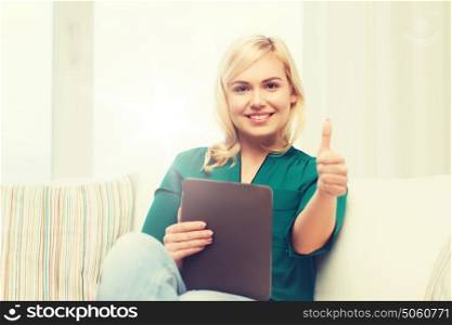 technology, internet and people concept concept - smiling woman sitting on couch with tablet pc computer at home. smiling woman with tablet pc at home