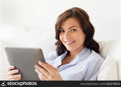 technology, internet and people concept concept - smiling woman with tablet pc computer at home