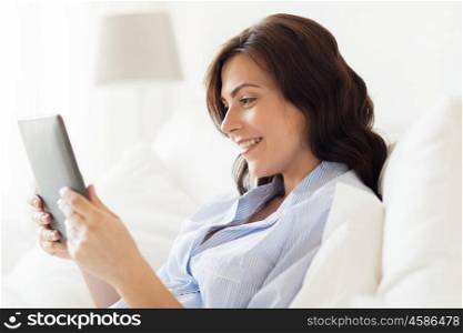 technology, internet and people concept concept - smiling woman with tablet pc computer at home