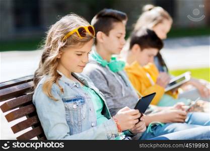 technology, internet and people concept - group of happy teenage friends or students with tablet pc computer outdoors