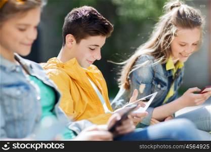 technology, internet and people concept - group of happy teenage friends or students with tablet pc computer outdoors