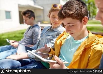 technology, internet and people concept - group of happy teenage friends or high school students with tablet pc computer outdoors