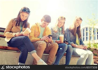 technology, internet and people concept - group of happy teenage friends with smartphone and coffee cups outdoors. teenage friends with smartphone and coffee cups. teenage friends with smartphone and coffee cups