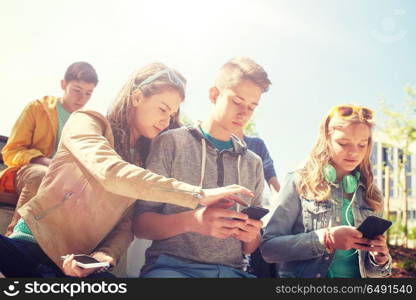 technology, internet and people concept - group of happy teenage friends with smartphone and headphones outdoors. teenage friends with smartphone and headphones. teenage friends with smartphone and headphones