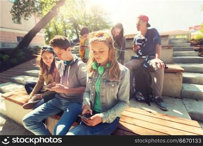 technology, internet and people concept - group of teenage friends with smartphones outdoors. group of teenage friends with smartphones outdoors. group of teenage friends with smartphones outdoors