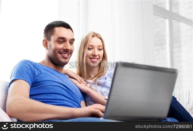 technology, internet and people concept - happy couple with laptop computer at home. happy couple with laptop computer at home