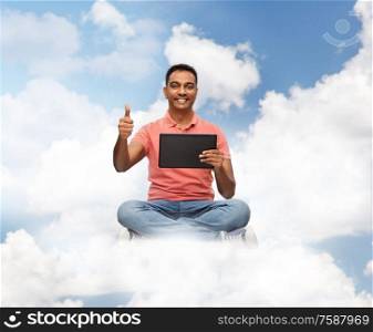 technology, internet and people concept - happy indian man with tablet computer in clouds over blue sky background. happy indian man with tablet pc showing thumbs up