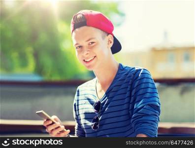 technology, internet and people concept - happy teenage boy with smartphone outdoors. happy teenage boy with smartphone outdoors. happy teenage boy with smartphone outdoors