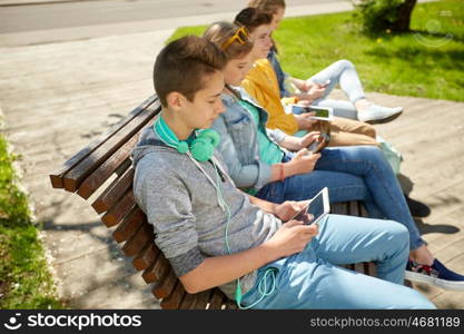 technology, internet and people concept - happy teenage boy with tablet pc computer and headphones outdoors