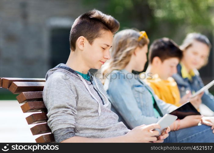 technology, internet and people concept - happy teenage boy with tablet pc computer outdoors