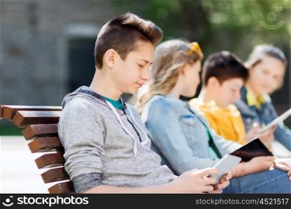 technology, internet and people concept - happy teenage boy with tablet pc computer outdoors