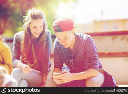 technology, internet and people concept - happy teenage friends with smartphones outdoors. happy teenage friends with smartphones outdoors