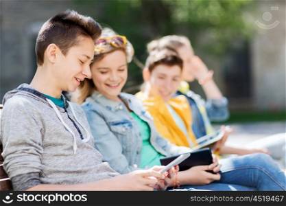 technology, internet and people concept - happy teenage friends with tablet pc computer outdoors