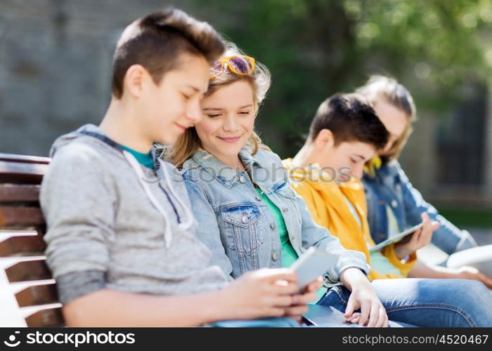 technology, internet and people concept - happy teenage friends with tablet pc computer outdoors