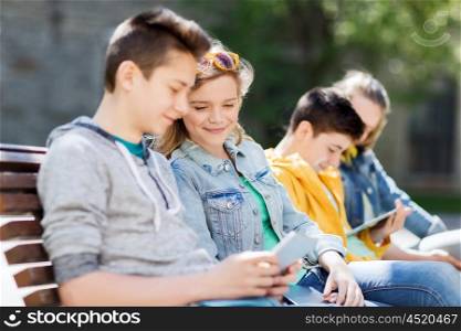 technology, internet and people concept - happy teenage friends with tablet pc computer outdoors