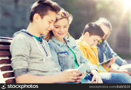 technology, internet and people concept - happy teenage friends with tablet pc computer outdoors. happy teenage friends with tablet pc outdoors. happy teenage friends with tablet pc outdoors