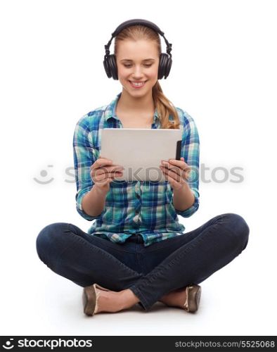 technology, internet and people concept - smiling young woman in casual clothes sitiing on floor with tablet pc computer and headphones