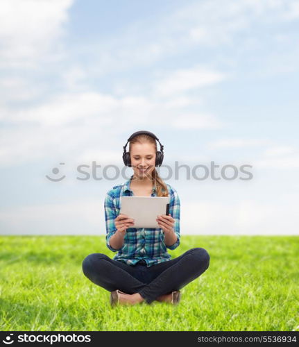 technology, internet and people concept - smiling young woman in casual clothes sitiing on floor with tablet pc computer and headphones