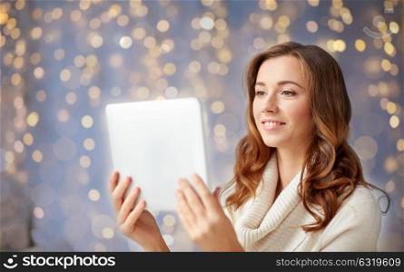 technology, internet, christmas and people concept - happy young woman with tablet pc computer at home. happy young woman with tablet pc at home