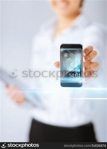 technology, internet, tv and news concept - woman hand with smartphone, videos and virtual screen