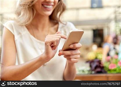 technology, leisure and people concept - close up of happy young woman with smartphone at street cafe. happy woman with smartphone at street cafe