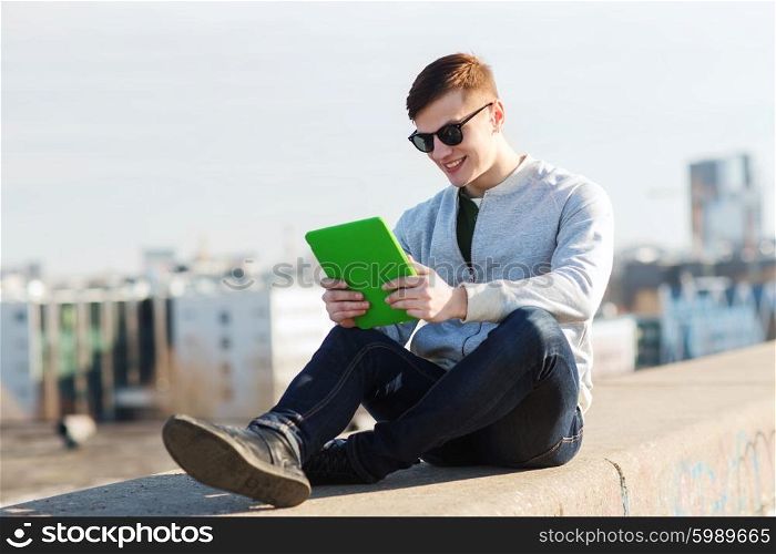 technology, lifestyle and people concept - smiling young man or teenage boy with tablet pc computers outdoors