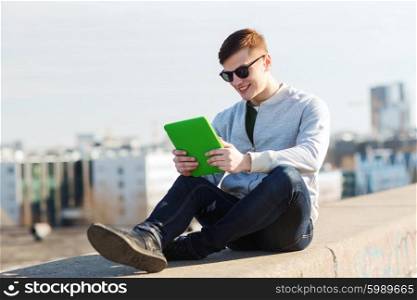 technology, lifestyle and people concept - smiling young man or teenage boy with tablet pc computers outdoors