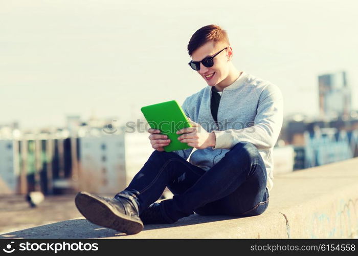 technology, lifestyle and people concept - smiling young man or teenage boy with tablet pc computers outdoors