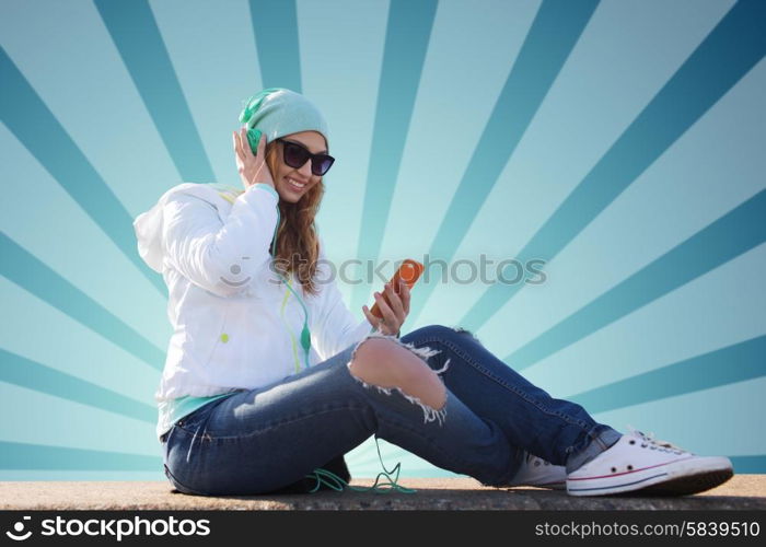 technology, lifestyle and people concept - smiling young woman or teenage girl with smartphone and headphones listening to music over blue burst rays background