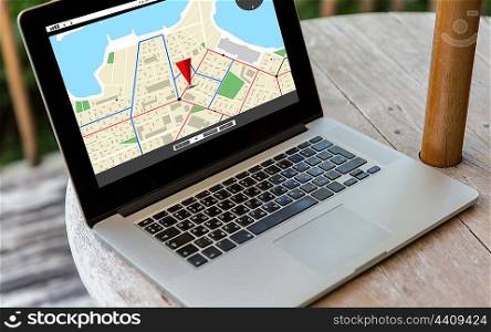 technology, location, navigation, business and modern life concept- close up of open laptop computer with gps navigator map on screen on table at hotel terrace