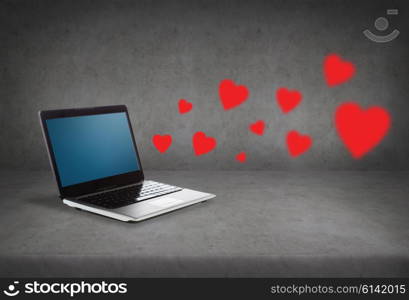 technology, love, communication and advertisement concept - laptop computer with blank screen and red hearts