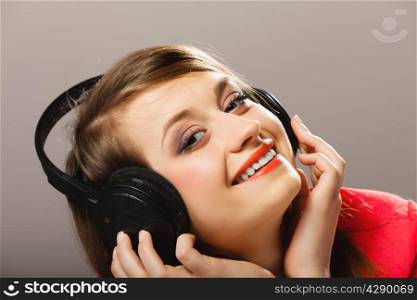 Technology, music and happiness concept - smiling girl teenage in headphones listening music