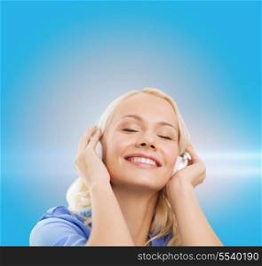 technology, music and happiness concept - smiling young girl in headphones