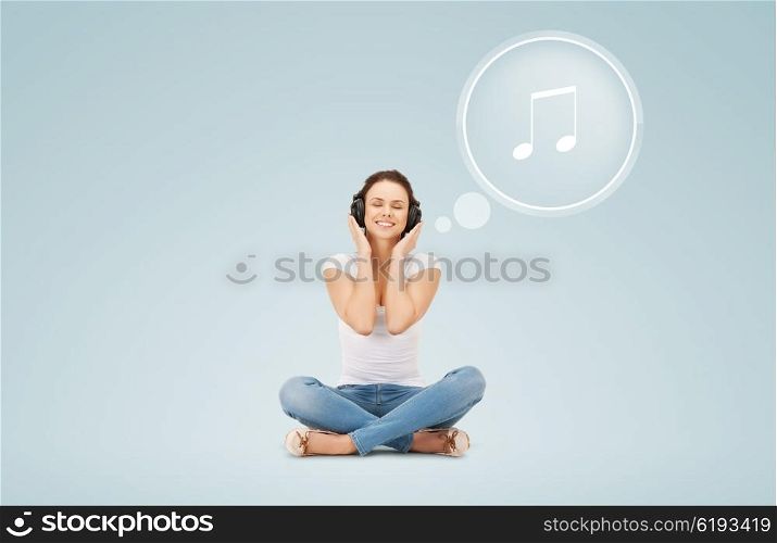 technology, music and happiness concept - smiling young woman or teen girl in headphones over blue background and musical note icon